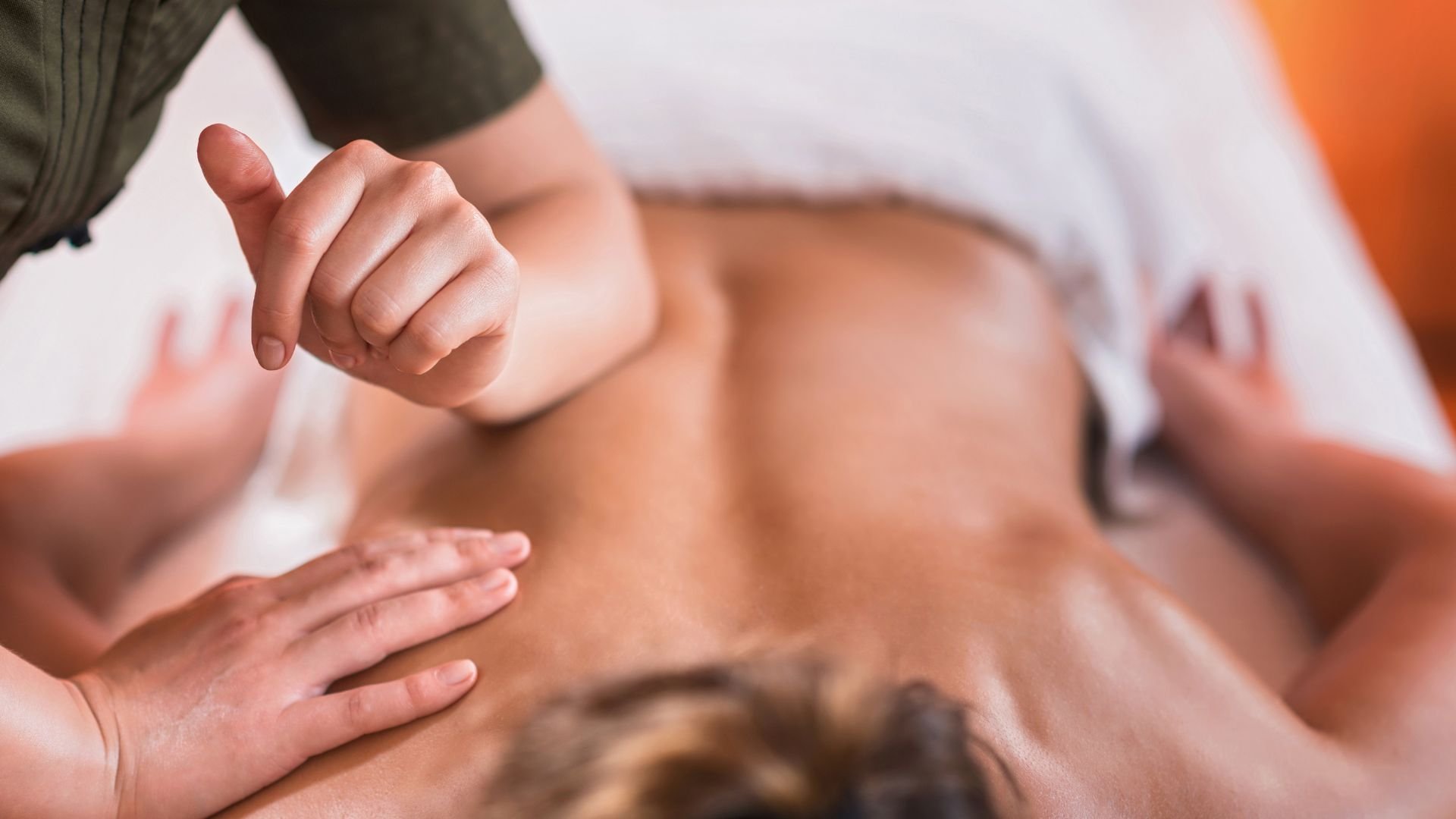 Massage therapist applying pressure during a professional back massage treatment